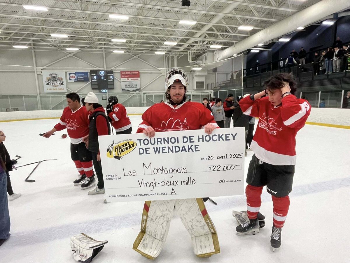 Goaltender Jesse Lahache Jr. celebrating on the ice with his teammates.