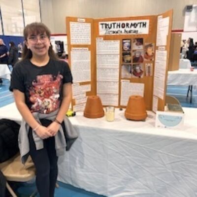 Kaylani Delormier in front of her project