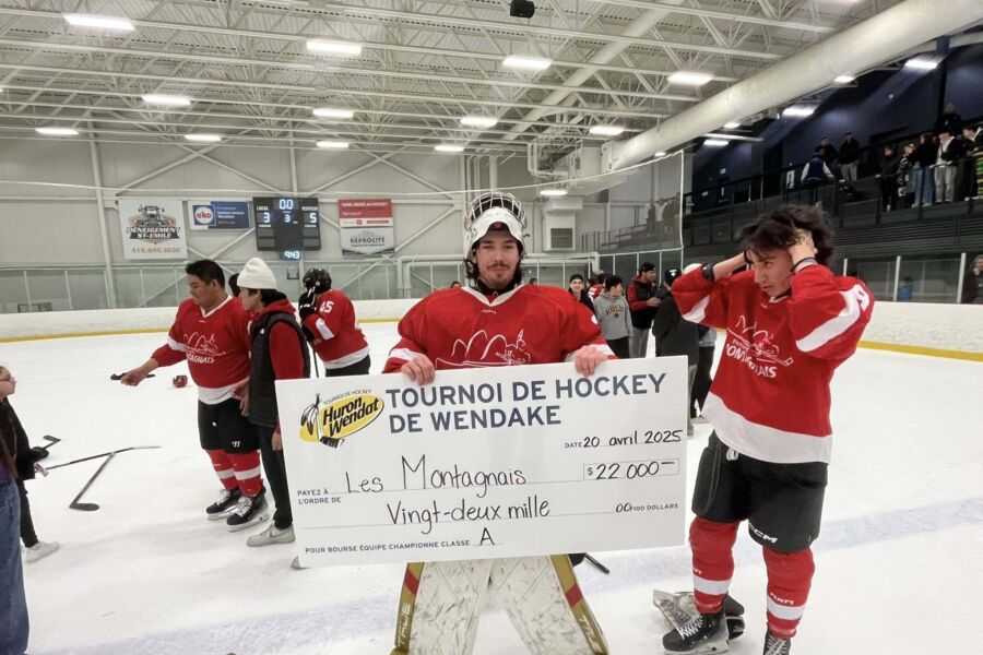 Goaltender Jesse Lahache Jr. celebrating on the ice with his teammates.