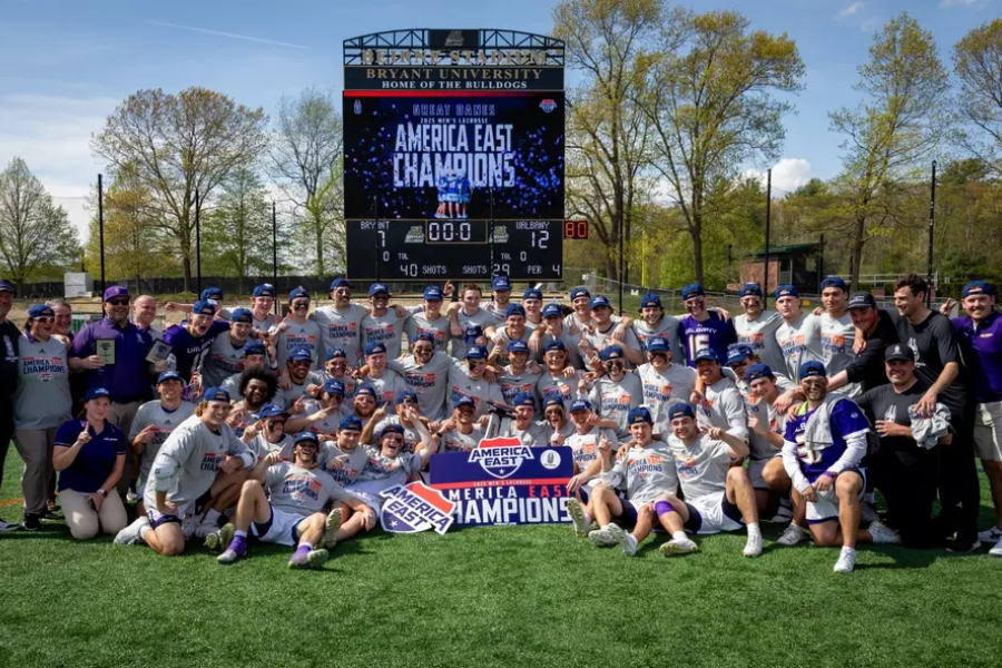 Koleton Marquis and the UAlbany Great Danes team posing in front of Bryant University